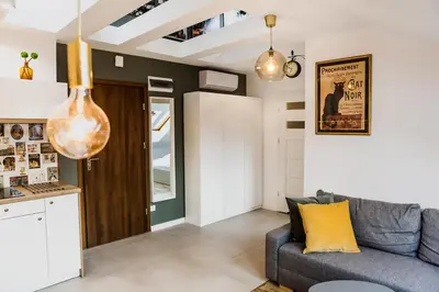 a living room with a couch and a kitchen at 1 - bedroom Apartment - Przemyska 4 Street in Kraków