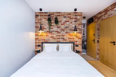 a bed in a room with a brick wall at Premium Vintage Apartament by Krakow Home in Kraków