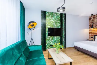 a living room with a green couch and a bed at Premium Vintage Apartament by Krakow Home in Kraków