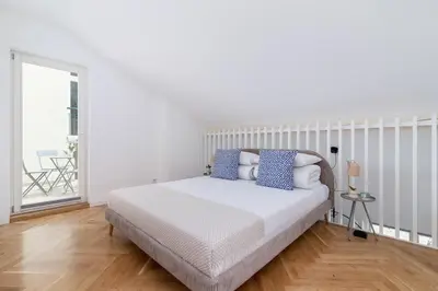 a white bedroom with a bed with blue pillows at Apartment with balcony - Rejtana 10 in Kraków