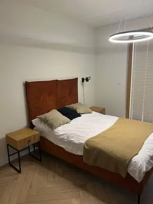 a bedroom with a large bed and a lamp at Tutu Kraków Comfort in Kraków