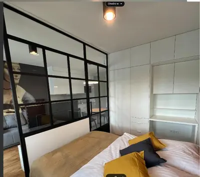 a bedroom with a bed and a large window at Tutu Kraków Comfort in Kraków