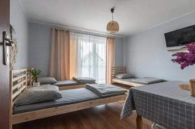a room with three beds and a window at Noclegi u Eweliny in Zator