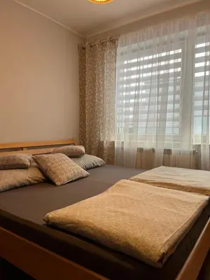 two beds in a bedroom with a window at Noclegi u Eweliny in Zator