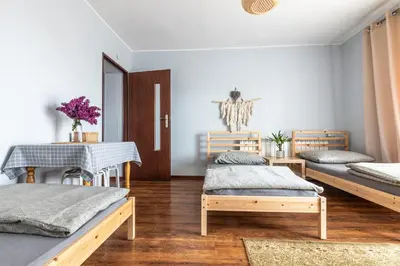 a room with three beds and a table at Noclegi u Eweliny in Zator