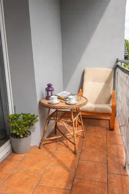 a small table and a chair on a balcony at Noclegi u Eweliny in Zator