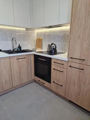 a kitchen with wooden cabinets and a tea kettle at Moje miejsce Zator in Zator