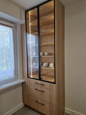 a wooden cabinet with glass doors in a room with a window at Moje miejsce Zator in Zator