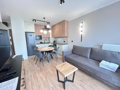 a living room with a couch and a table at ApartmentPrestige Soho in Kraków
