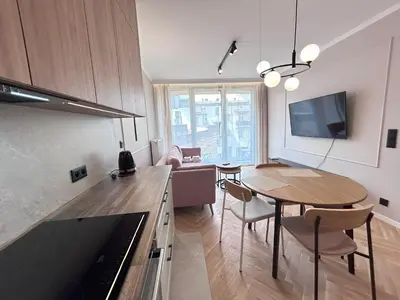 a kitchen with a table and a dining room at ApartmentPrestige Soho in Kraków