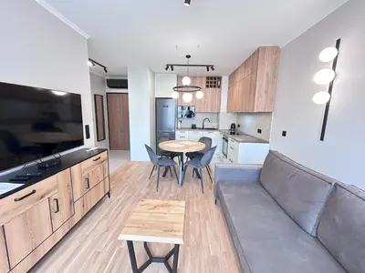a kitchen and living room with a couch and a table at ApartmentPrestige Soho in Kraków