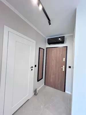 a hallway with a wooden door and a room at ApartmentPrestige Soho in Kraków