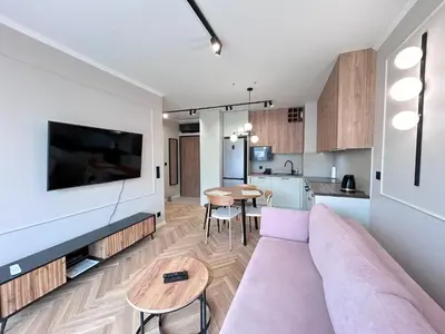 a living room with a couch and a table at ApartmentPrestige Soho in Kraków