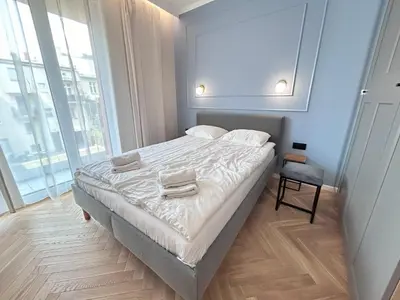 a bedroom with a bed with two items on it at ApartmentPrestige Soho in Kraków