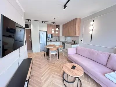 a living room with a purple couch and a table at ApartmentPrestige Soho in Kraków