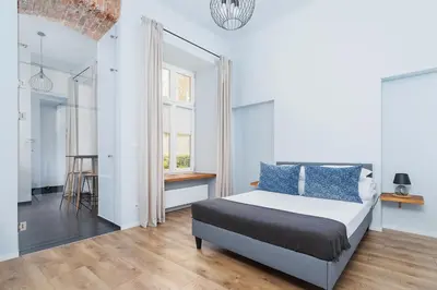 a white bedroom with a bed and a window at One bedroom apartment - Sarego 28 Street in Kraków