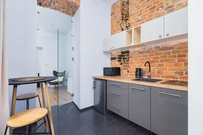 a kitchen with a table and a brick wall at One bedroom apartment - Sarego 28 Street in Kraków
