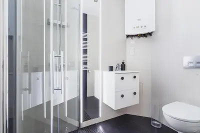 a white bathroom with a toilet and a shower at One bedroom apartment - Sarego 28 Street in Kraków