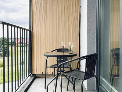 a table with two wine glasses on a balcony at Zator 36 by Housine in Zator