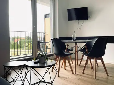 a balcony with two chairs and a table with wine glasses at Zator 36 by Housine in Zator