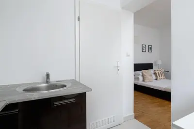 a bathroom with a sink and a room with a bed at Studio apartment with AC - Długa 65 in Kraków