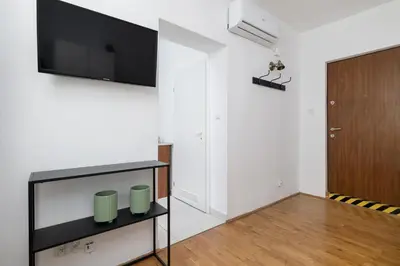 a living room with a flat screen tv on a wall at Studio apartment with AC - Długa 65 in Kraków
