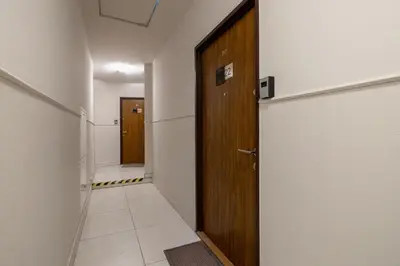 a hallway with a wooden door and a tile floor at Studio apartment with AC - Długa 65 in Kraków