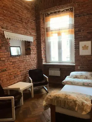 a bedroom with two beds and a brick wall at wawel hostel in Kraków