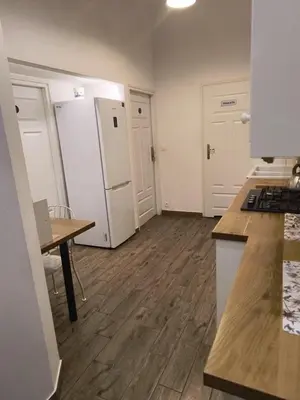 an empty kitchen with a refrigerator and a table at wawel hostel in Kraków