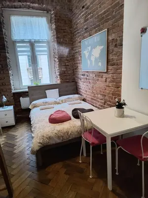 a bedroom with a bed and a brick wall at wawel hostel in Kraków