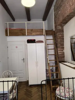 a room with a bunk bed and a ladder at wawel hostel in Kraków