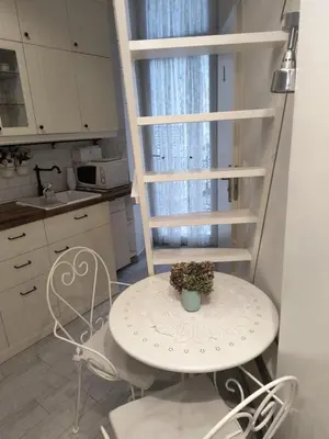 a small white table and chairs in a kitchen at wawel hostel in Kraków
