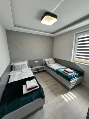 a bedroom with two beds and a window at Apartament Jasmin in Zator