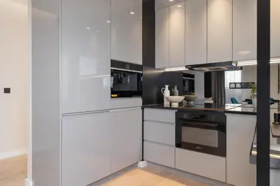 a kitchen with white cabinets and black appliances at Exclusive Apartment on the Vistula River in Kraków by Renters Prestige in Kraków
