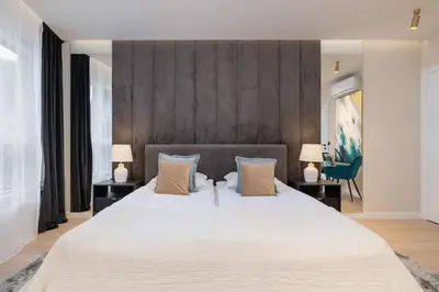 a bedroom with a large white bed with two lamps at Exclusive Apartment on the Vistula River in Kraków by Renters Prestige in Kraków