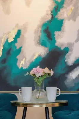 a table with two cups and a vase with flowers at Exclusive Apartment on the Vistula River in Kraków by Renters Prestige in Kraków