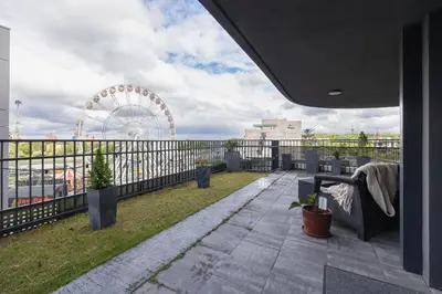 a balcony with a ferris wheel in the background at Exclusive Apartment on the Vistula River in Kraków by Renters Prestige in Kraków