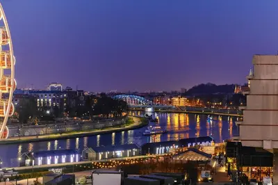 a view of a city with a river at night at Exclusive Apartment on the Vistula River in Kraków by Renters Prestige in Kraków