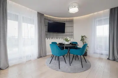 a dining room with a table and blue chairs at Exclusive Apartment on the Vistula River in Kraków by Renters Prestige in Kraków
