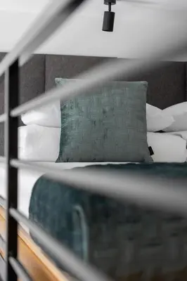 a bed with white pillows and a green pillow at Kazimierz - Balcony Apartment- Starowiślna 41 in Kraków