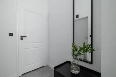 a vase on a table next to a mirror at Kazimierz - Balcony Apartment- Starowiślna 41 in Kraków