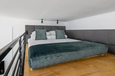 a bedroom with a large bed with a green blanket at Kazimierz - Balcony Apartment- Starowiślna 41 in Kraków