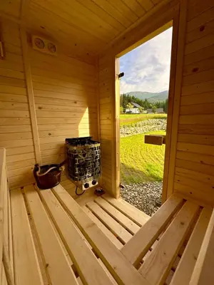 a wooden porch with a bench and a table at Domek SAMI SWOI in Zawoja