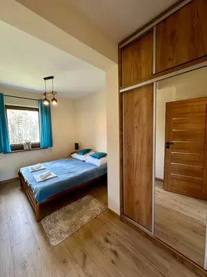 a kitchen with wooden cabinets and a stove top oven at Domek SAMI SWOI in Zawoja