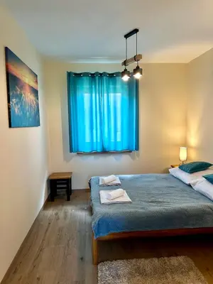 a bedroom with a bed and a large wooden door at Domek SAMI SWOI in Zawoja