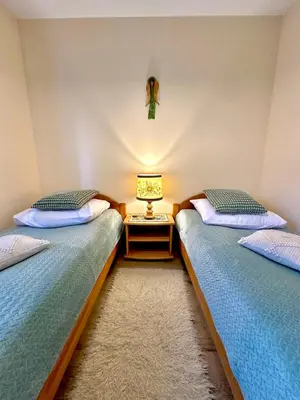 a bedroom with two beds and a window at Domek SAMI SWOI in Zawoja