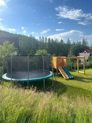 a trampoline and a bench in a yard at Domek SAMI SWOI in Zawoja