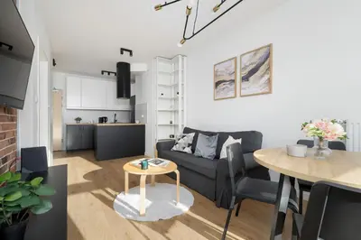 a living room with a couch and a table at Mogilska Apartments with Parking near TAURON Arena Kraków by Noclegi Renters in Kraków