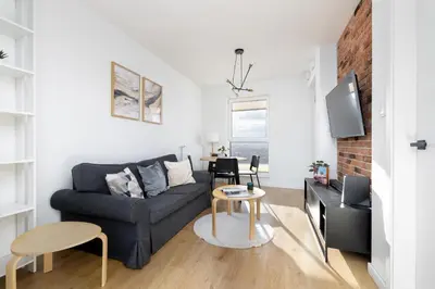 a living room with a couch and a table at Mogilska Apartments with Parking near TAURON Arena Kraków by Noclegi Renters in Kraków