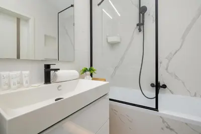 a white bathroom with a shower and a sink at Mogilska Apartments with Parking near TAURON Arena Kraków by Noclegi Renters in Kraków